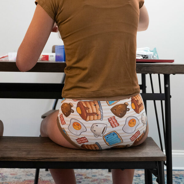 a girl sitting at a table from behind