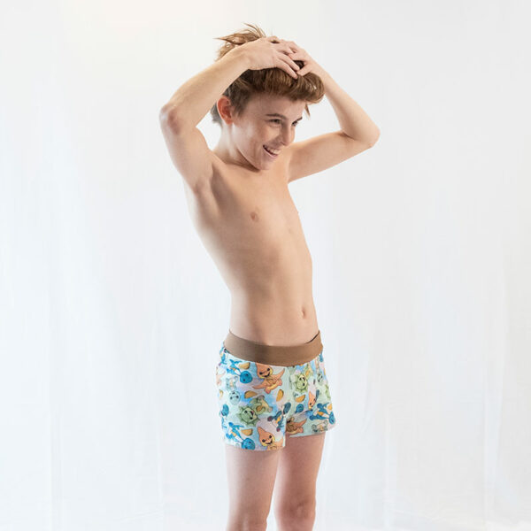 a boy posing on a white backdrop in his boxers