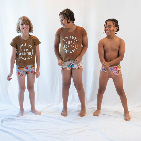 three boys posing on a white backdrop in their boxers